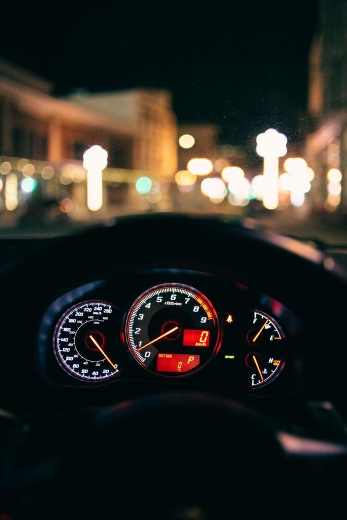 glowing dashboard of modern car driving in illuminated city street
