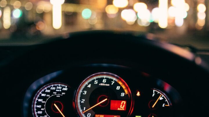 glowing dashboard of modern car driving in illuminated city street